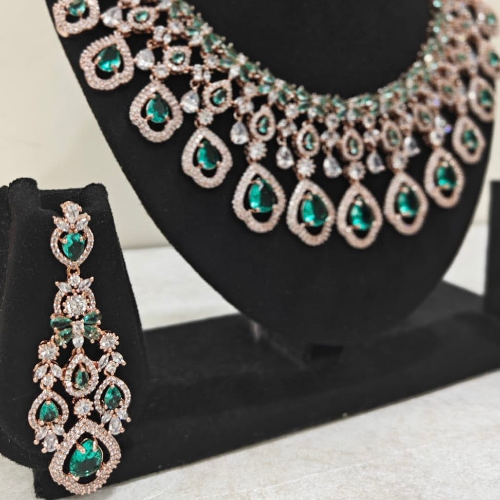 Elegant bridal necklace set with emerald green stones and matching earrings in rose gold finish