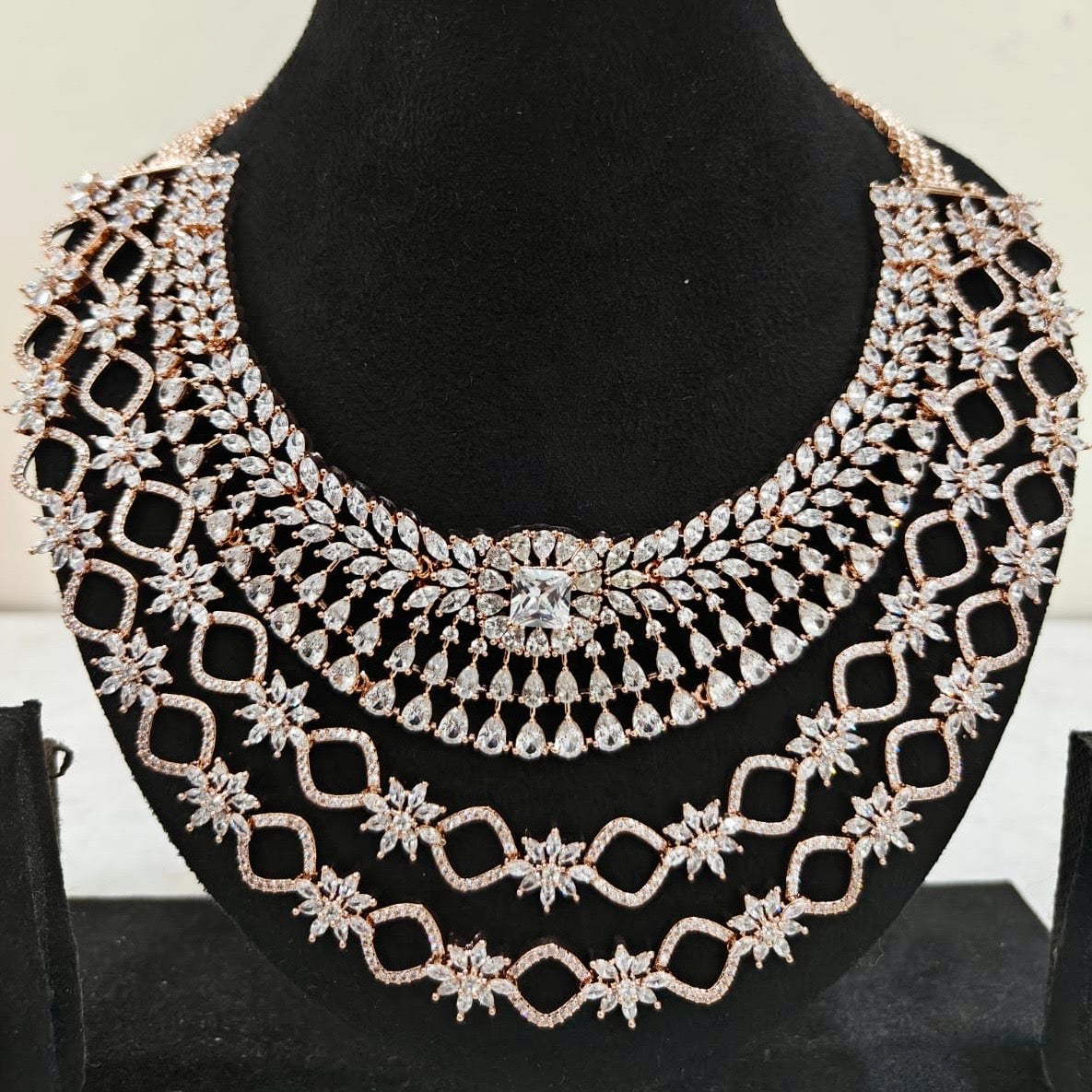 Close-up of rose gold American Diamond necklace with layered starburst design