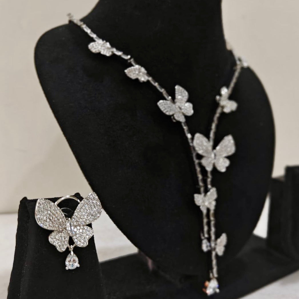 Delicate butterfly motif necklace with matching earrings on black stand