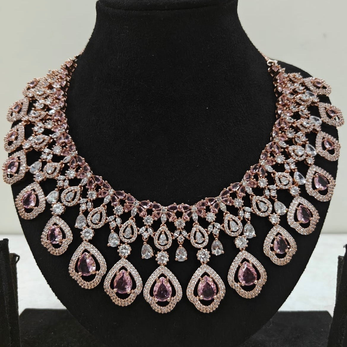 Close-up of rose gold American Diamond necklace with pink teardrop stones and intricate detailing