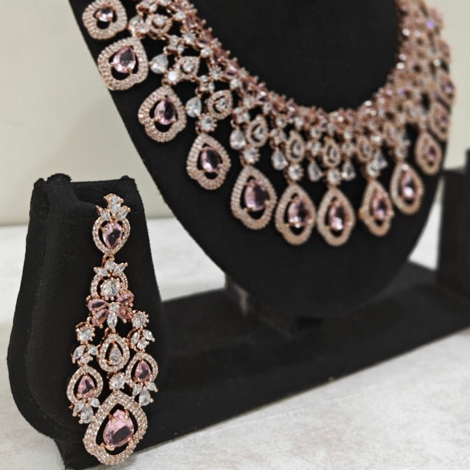 Statement earrings with pink teardrop stones and matching rose gold American Diamond necklace