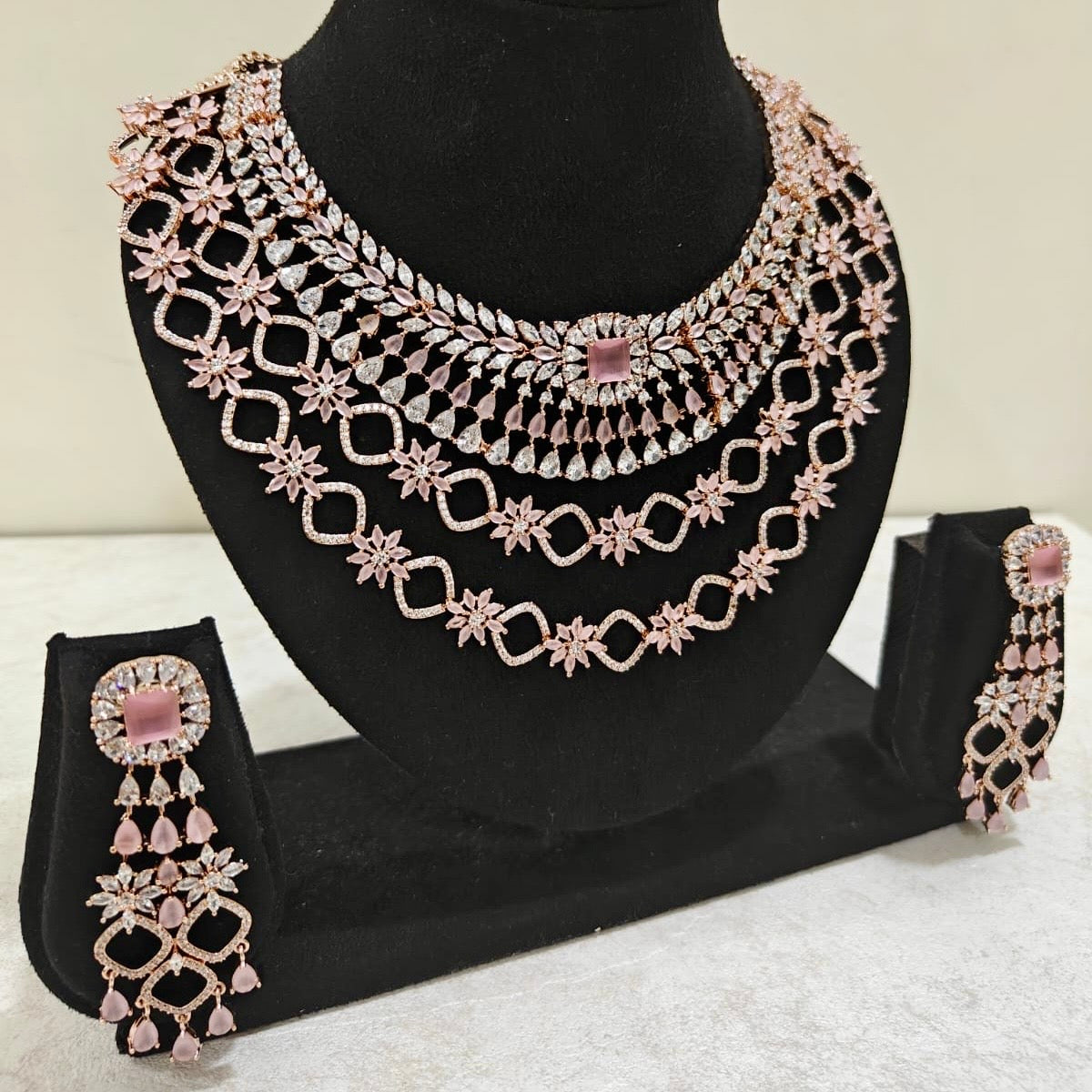 Side view of blush pink layered American Diamond necklace and matching earrings