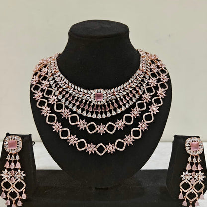 Blush pink multi-layer bridal necklace set with sparkling American Diamonds on black stand
